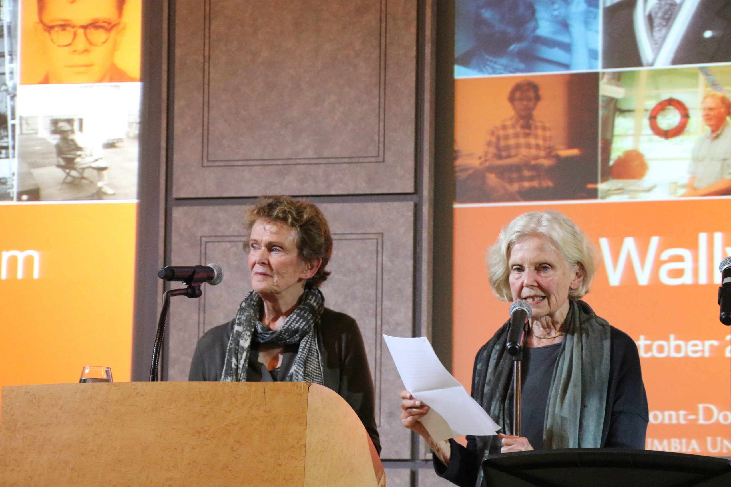 Two women giving a speech on a podium.